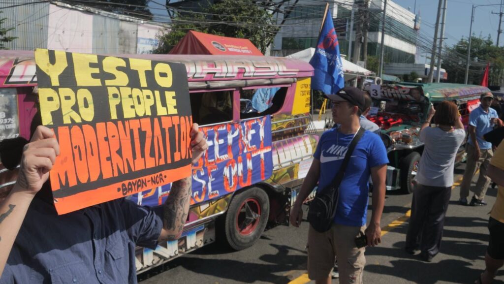 PISTON - man holding a sign saying 'Yes to pro-people modernization!'